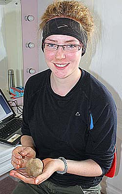 Willamette student Molly Bond with the carved stone ball she found today. (Sigurd Towrie)