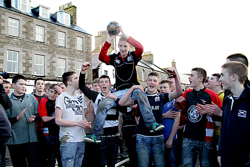 Greg Scott, the winner of the 2014 Christmas Day Boys' Ba', is held aloft by his fellow Doonie players.