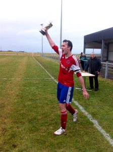 Captain Erik Bews lifts the Ness Cup after Orkney beat Golspie Sutherland 1-0 in the final last year.