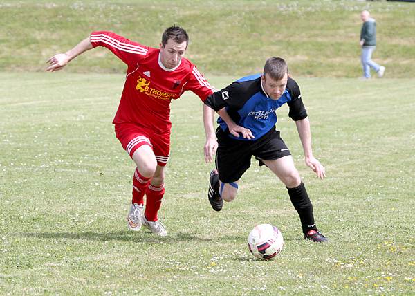 Holm's Chris Simpson and Sanday's Edrian Skea battles for the ball during Holm's 3-2 first-leg victory.