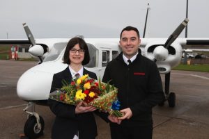 Anne Rendall being presented with a celebratory bouquet of flowers by newly appointed route captain Alex Rendall.