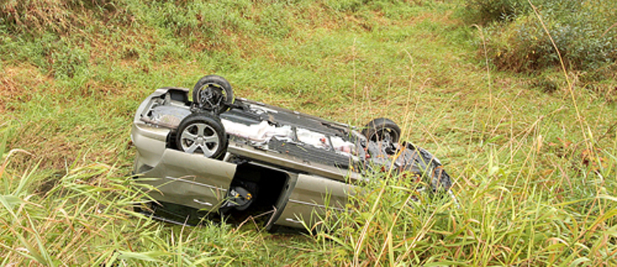 "A wrecked (rolled) minivan that's upside-down in a swamp, with other vehicles speeding past. The driver and two small children escaped unharmed because of the seatbelt and child-seats.All images in this series..."