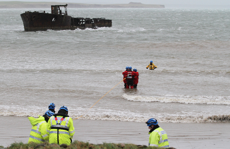 Coastguards on an exercise at Inganess Beach using the rescue technique to recover a person from the sea.